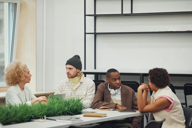 A diverse group of colleagues engaging in a collaborative meeting in a modern office setting. Community launch planning